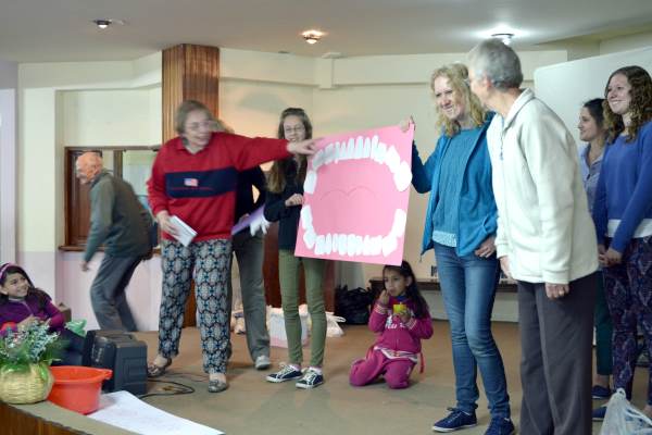 Using a cardboard and paper model of a mouth and teeth to teach about dental hygiene