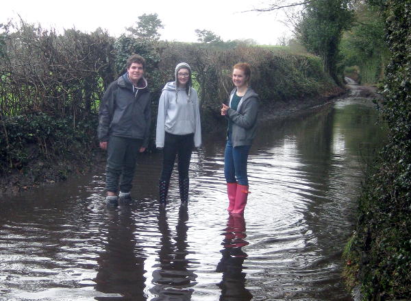 Reloaded members standing in a flooded road