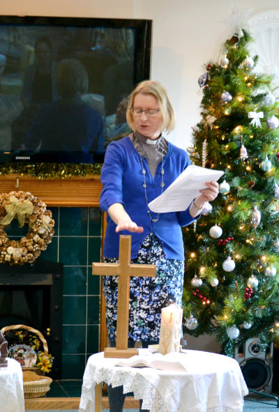 Megan Gibbins leading a Christmas celebration in Neville Williams House