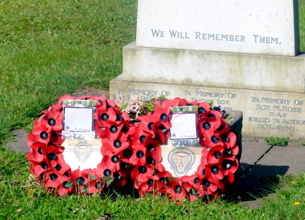 Poppy wreaths at the foot of a war memorial