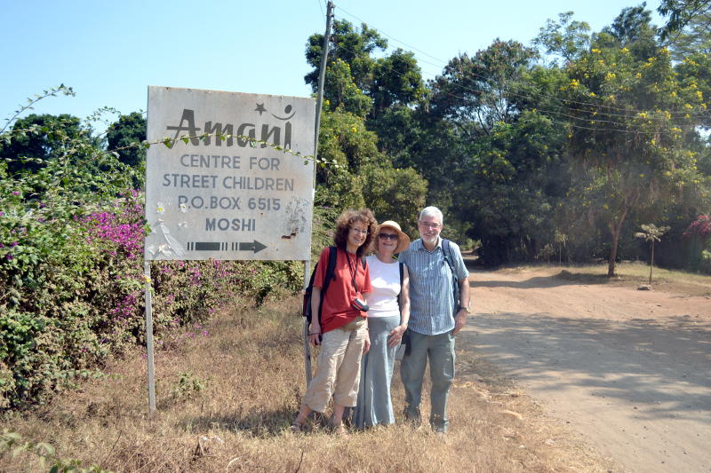 Christ Church members standing next to the Amani Children's Home sign