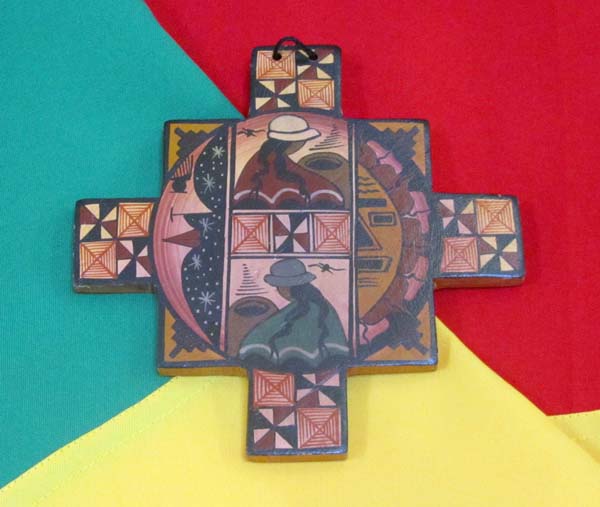 A decorated wooden cross resting on a Bolivian flag