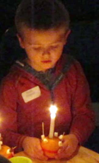 A Christingle with lighted candle