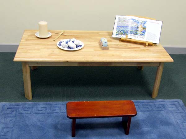 A low table with a book, a candle and small stones