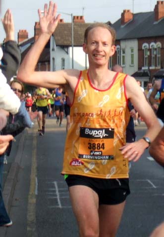 A runner raises his hand to acknowledge the crowd