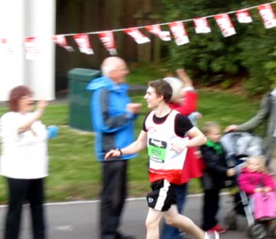 A younger entrant runs past the crowd
