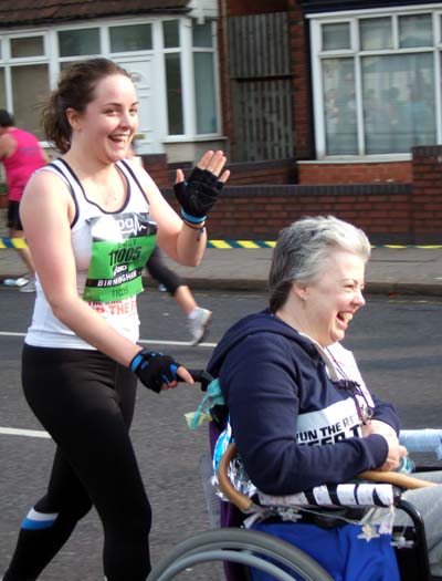 A daughter pushes her mother in a wheelchair