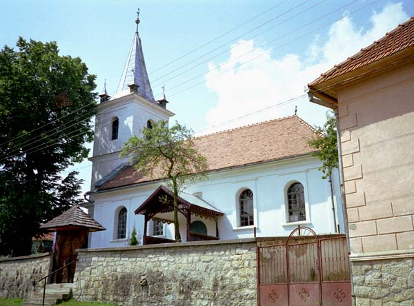 Side view of a whitewashed church with a spire