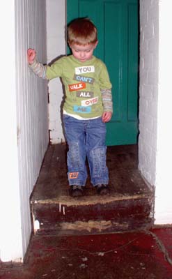 A small child looks down at a step