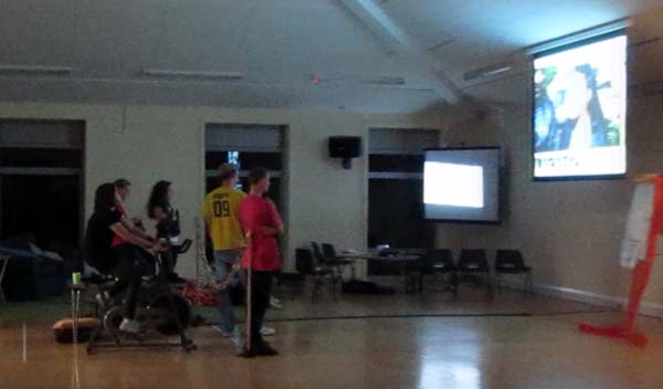 The cyclists and other spectators watch a film