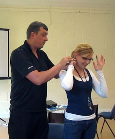 A policeman finds the pressure points under Ellen's ears