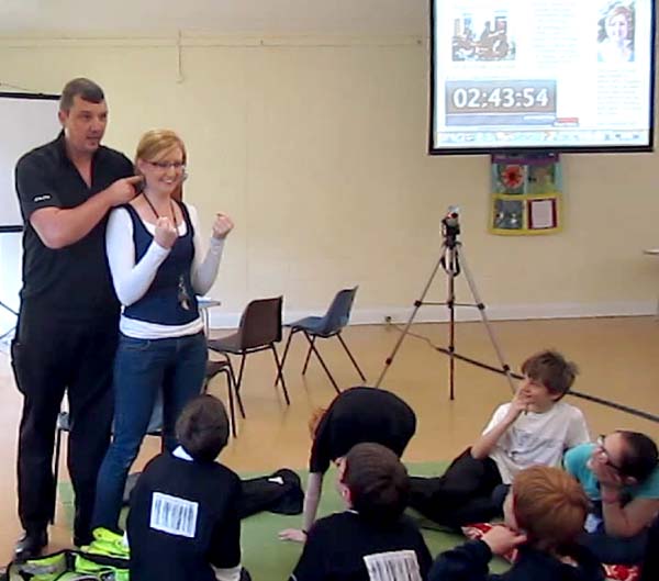 Members of Revive watch as a police officer locates Ellen's pressure points