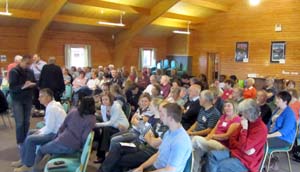 A large room full of people viewed from the side