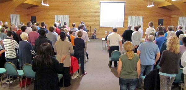 A large room full of people viewed from the back