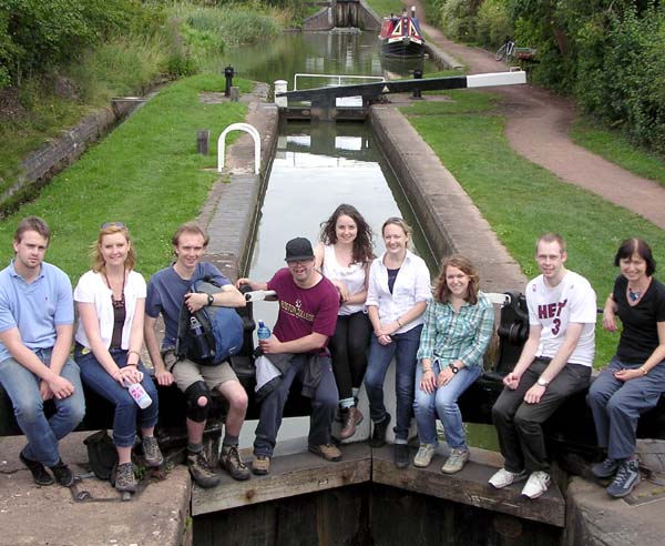 A group of young adults sitting on a canal lock gate